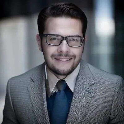 Homem sorridente usando terno e óculos